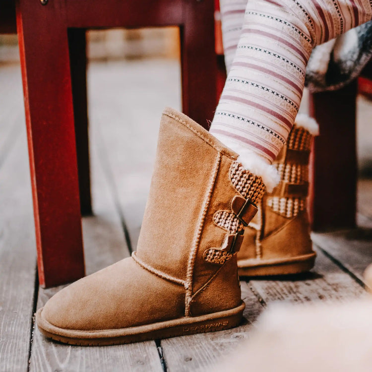 Bottes en suédé marron avec des accents tricotés décoratifs.