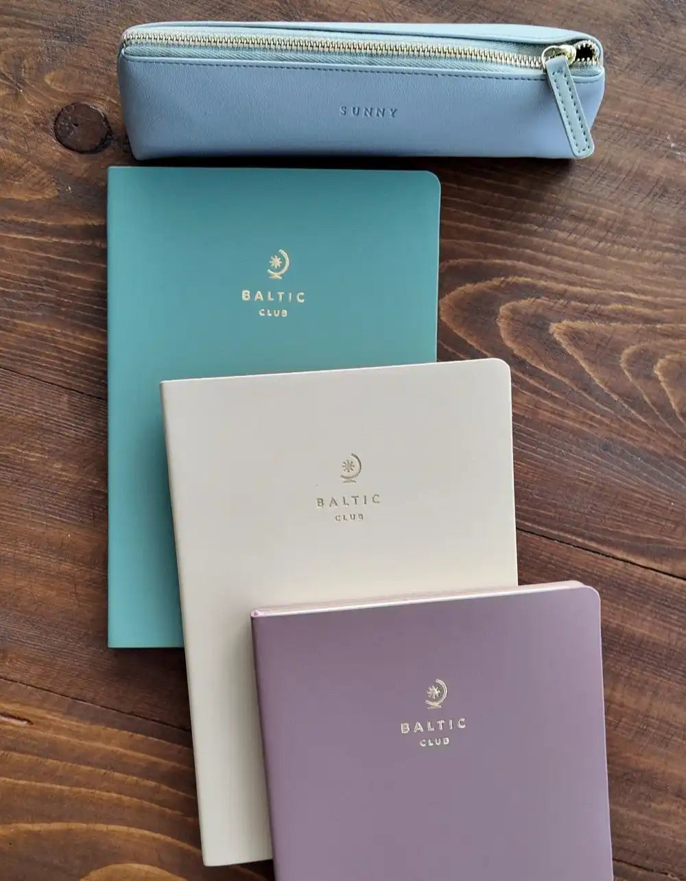 Collection de cahiers Baltic Club et d'une trousse dans des couleurs pastel.