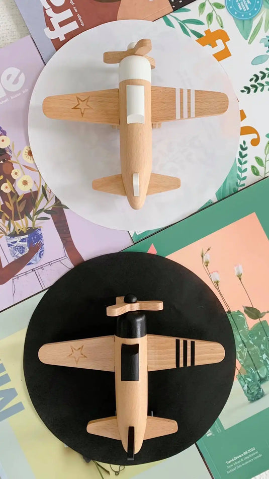 Deux avions en bois jouets avec des rayures noires montés sur des bases d'affichage circulaires.