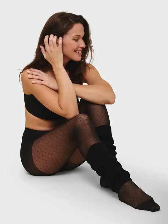 Femme en collants à pois noirs et en jambières.